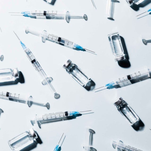 Syringes and vials arranged on a surface.