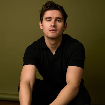Male crouching against a green background.