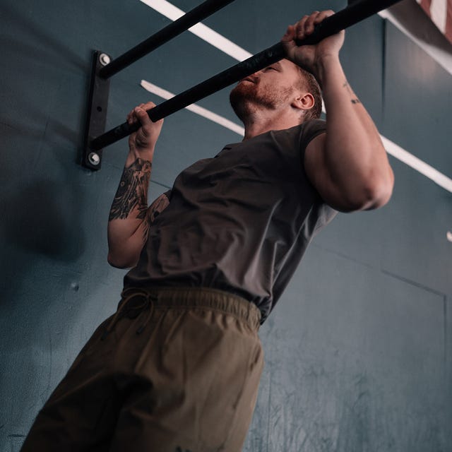 Individual performing a pull-up on a bar.