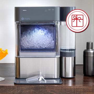 Ice maker with cocktails and bar tools in a modern kitchen setting. Ice maker with cocktails and bar tools in a modern kitchen setting.