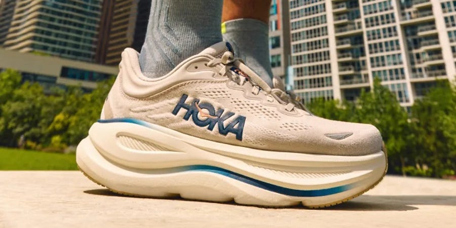 Close-up of a sneaker outdoors with a city skyline in the background.