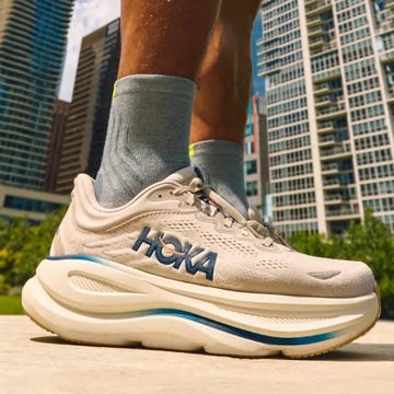 Close-up of a sneaker outdoors with a city skyline in the background.
